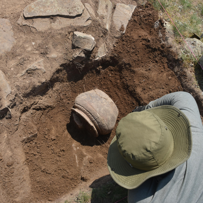 An aerial view of a mountainous region in Central Asiua shows what looks like a mountaintop partly covered by trees and partly open field. Researchers have found traces of a medieval city there.